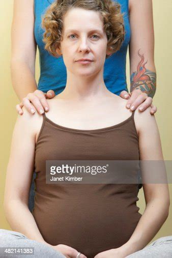 caucasian lesbian holding pregnant girlfriends shoulders high res stock