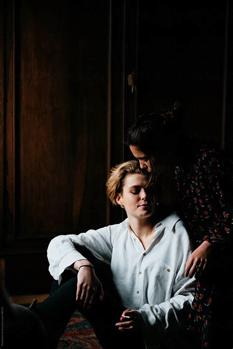 portrait of a beautiful lesbian teen couple in a dark room by stocksy