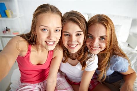friendship people pajama party and fun concept happy friends or teenage girls taking selfie