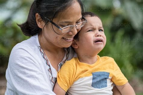 image of asian mother comforts her crying 2 year old son