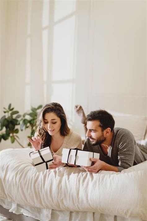 Beautiful Couple In Love Lying In The Bed And Make A Present To Each