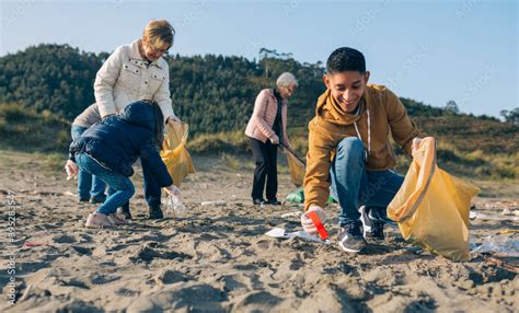 young man picking  trash  group  volunteers   beach stock