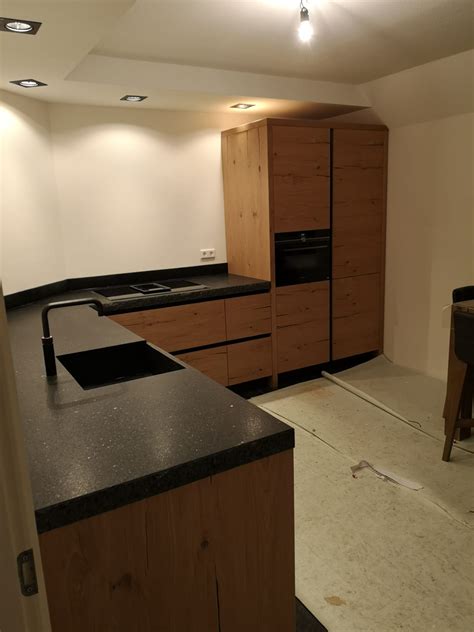 moderne greeploze eiken keuken met zwart blad de lange keukens