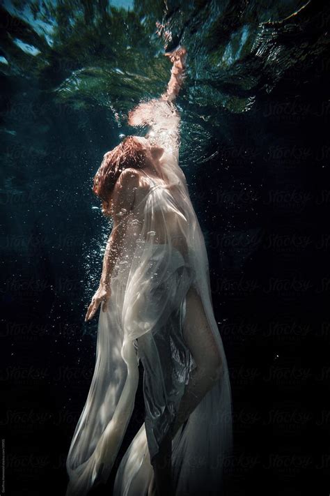 a woman in white dress under water