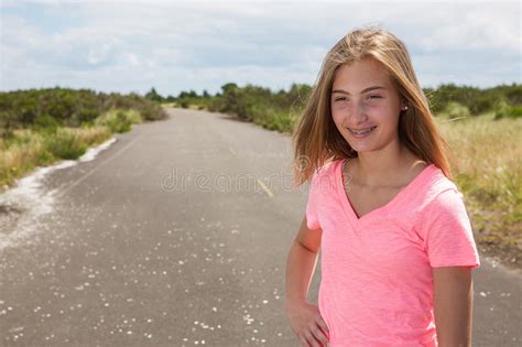 a teenage girl travels barefoot on an empty road stock