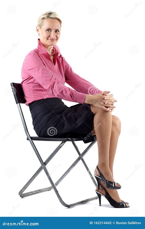 Successful Mature Business Woman Sitting On A Black Chair On White