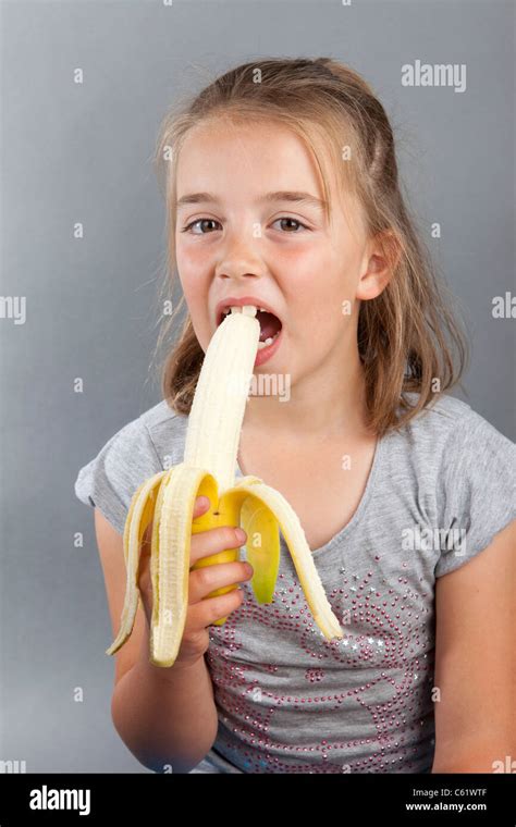 ein junges mädchen eine reife geschälte banane essen stockfoto bild