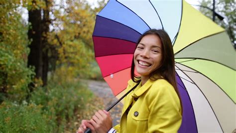 fall autumn concept woman excited under rain with umbrella