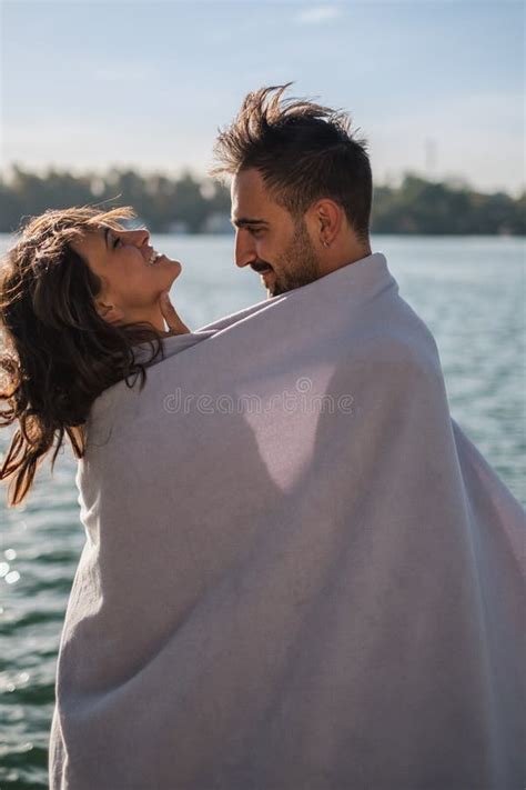 Smiling Couple Covered With Blanket Having Fun By The River Stock Image