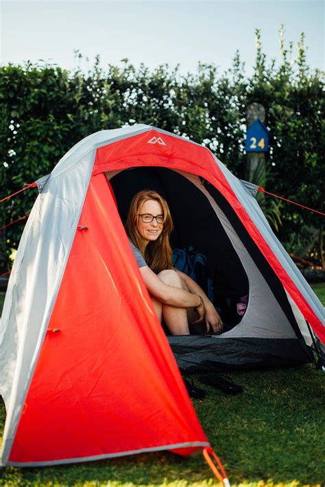 redhead backpacker girl camping in her tent in new zealand by ellen