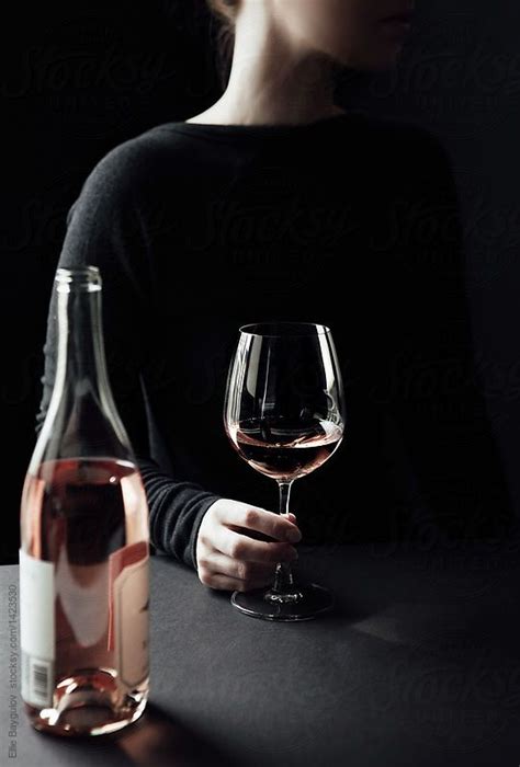 woman holding glass of wine by ellie baygulov women drinking wine