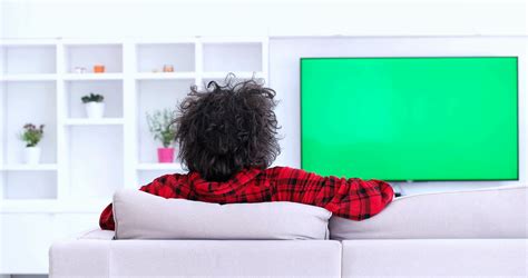 young man watching television green screen  living room green screen