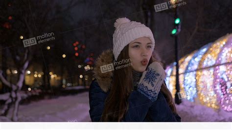 the girl warms her hands with her breath in winter it is very cold