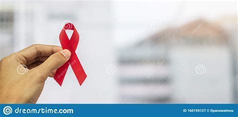 december world aids day awareness month man holding red ribbon for