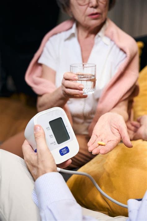 elderly wife gives her husband pills and glass of water stock image