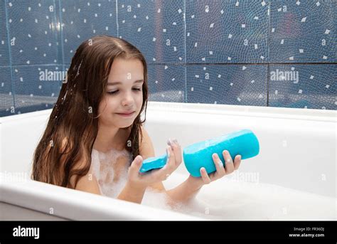Little Smiling Girl With Long Brown Hair Taking A Bath With A Blue