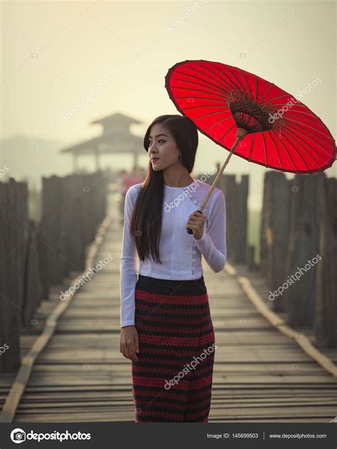 myanmar woman in traditional dress walking on the u bein