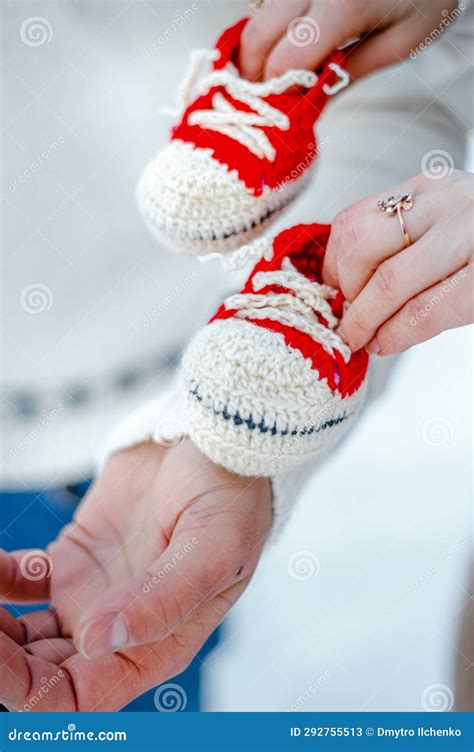 the wife gives her husband small knitted shoes for the newborn stock
