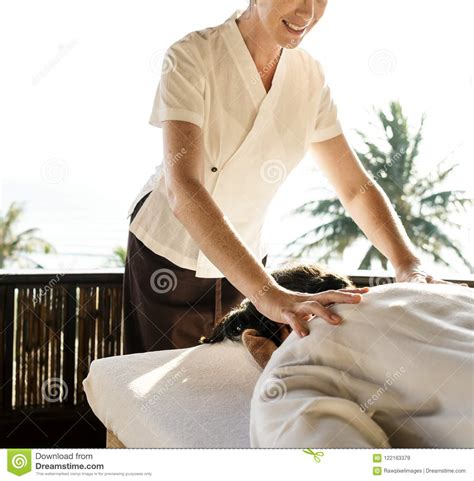 female massage therapist giving a massage at a spa stock