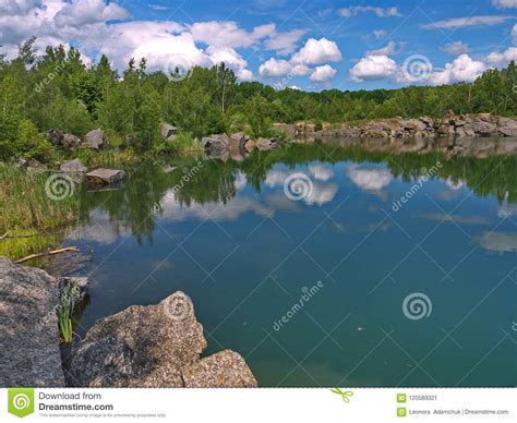 banks   lake  lined  large stone blocks    white clouds  reflected