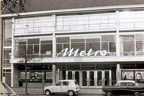 black  white photo  cars parked  front   metro storefront