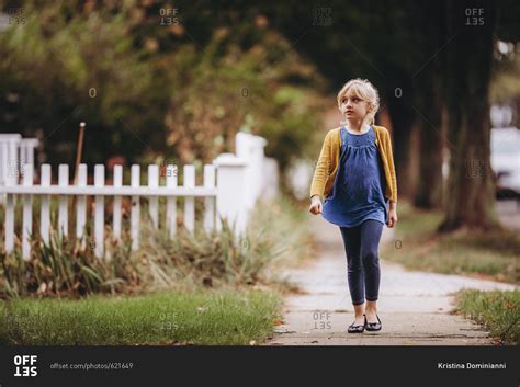young girl walking   sidewalk stock photo offset