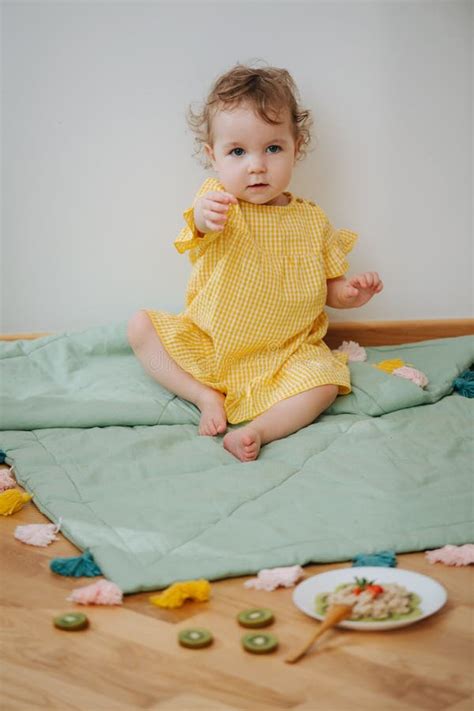 Cute Babe Sitting In The Game Zone Is Ready To Eat Oatmeal Stock Image