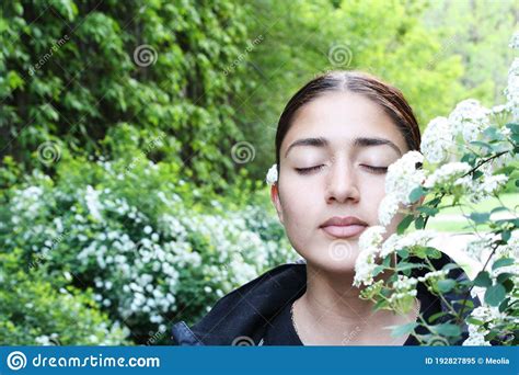 Beautiful Girl Surrounded By Green Plants And White Flowers Stock Image