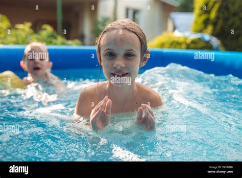 Two Cheerful Cute Little Sisters Playing And Having Fun Splashing And