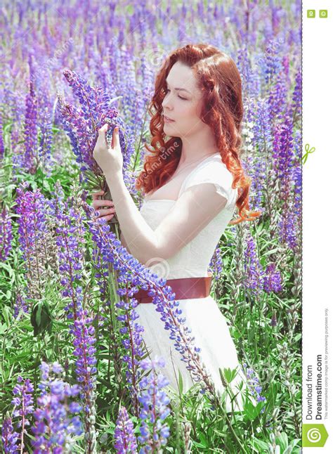 Redhead Woman With Long Hair In Lupine Field Stock Image