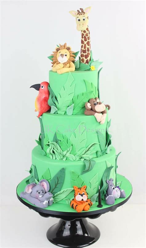 tiered cake decorated  animals  leaves   black stand   white background