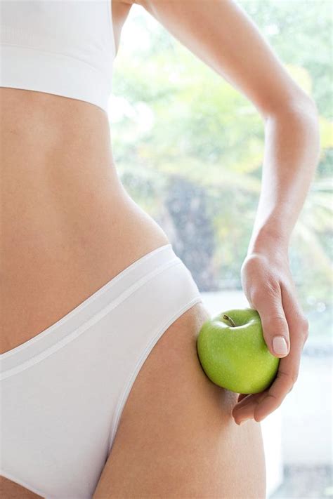 woman wearing white underwear holding apple photograph by ian hooton