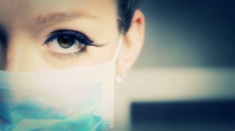 Doctor Or Nurse Woman With Blue Surgical Mask Showing Her Eyes And