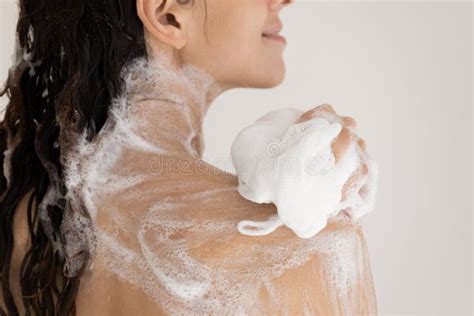 Close Up Woman Taking Shower With Moisturizing Soap Using Puff Stock