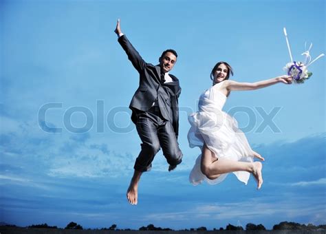 eben verheiratetes paar springen vor freude stockfoto colourbox