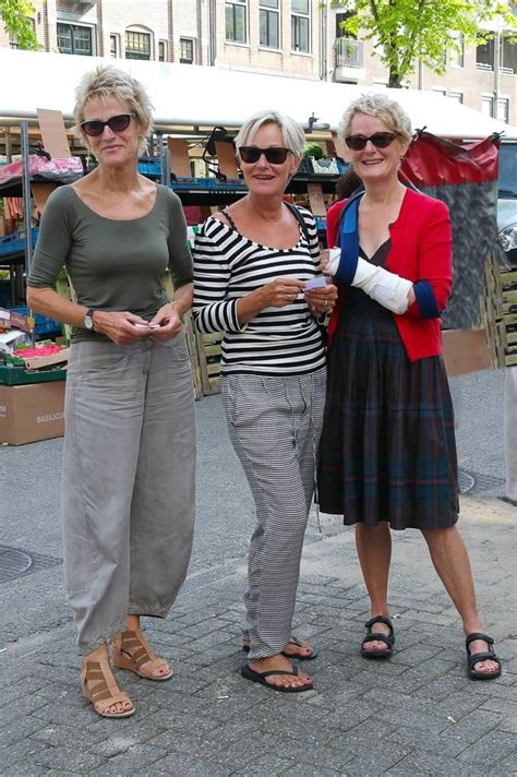 three women standing next to each other on a street
