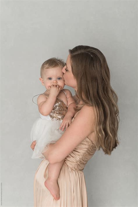mother kissing her daughter by stocksy contributor alison winterroth
