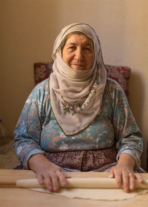 people elderly turkish woman rolling dough with rolling pin john