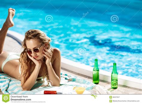 Beautiful Blonde Girl In Swimwear Sunbathing Lying Near