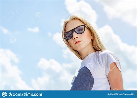 Summer Portrait Of A Blonde Girl In Sunglasses On A Background Of The