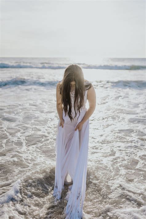 A Woman Is Standing In The Water At The Beach