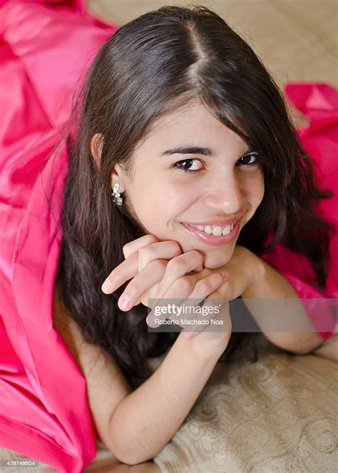 A Dark Haired Teenager Girl Rests Her Chin On Her Hands While