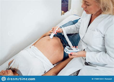 a gynecologist examines a pregnant woman fetal doppler