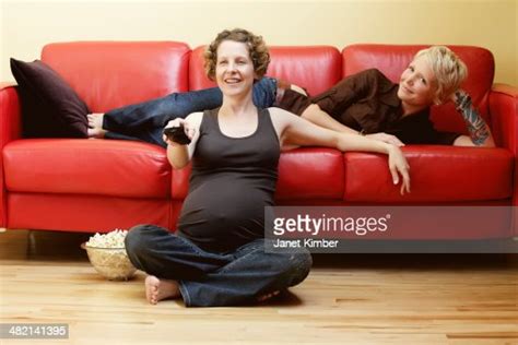 caucasian pregnant lesbian couple watching tv photo getty images