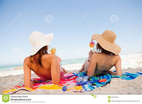 Back View Of Beautiful Women Sunbathing While Sipping