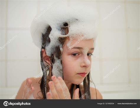 洗澡间里的小女孩 小女孩在用泡沫泡的浴缸里洗澡 — 图库照片©kapinosova＃321692034