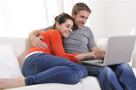 happy couple online shopping having fun on laptop on sofa