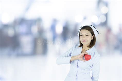 De Aziatische Verpleegster Houdt Een Rode Hartvorm Op Het Ziekenhuis