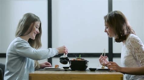 two girls gossiping in a japanese restaurant by photo oles