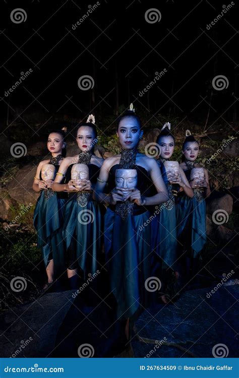 A Group Of Javanese Women Standing In The Woods Between The Rocks While